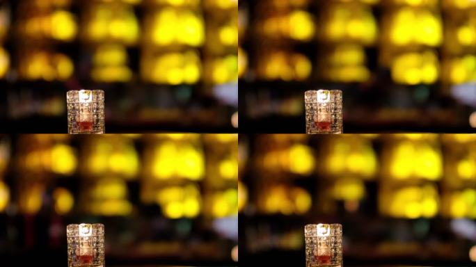 夜晚酒吧吧台上的蜡烛和光斑人影