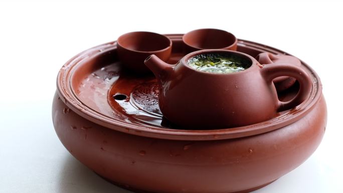 一套紫砂壶茶具和热气腾腾的茶水，白色背景