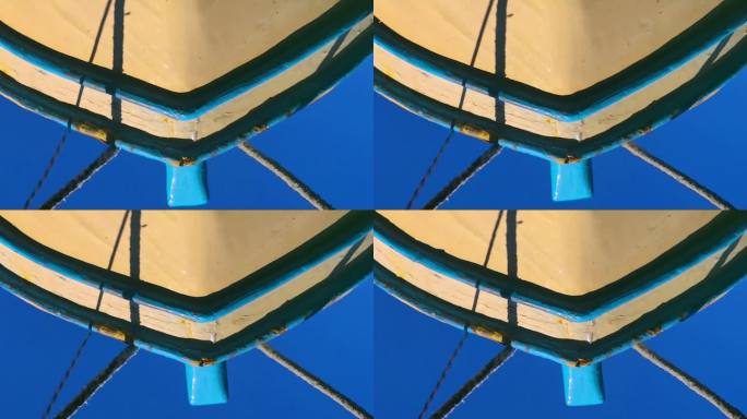 木渔船和系泊绳在蓝色海水中的倒影