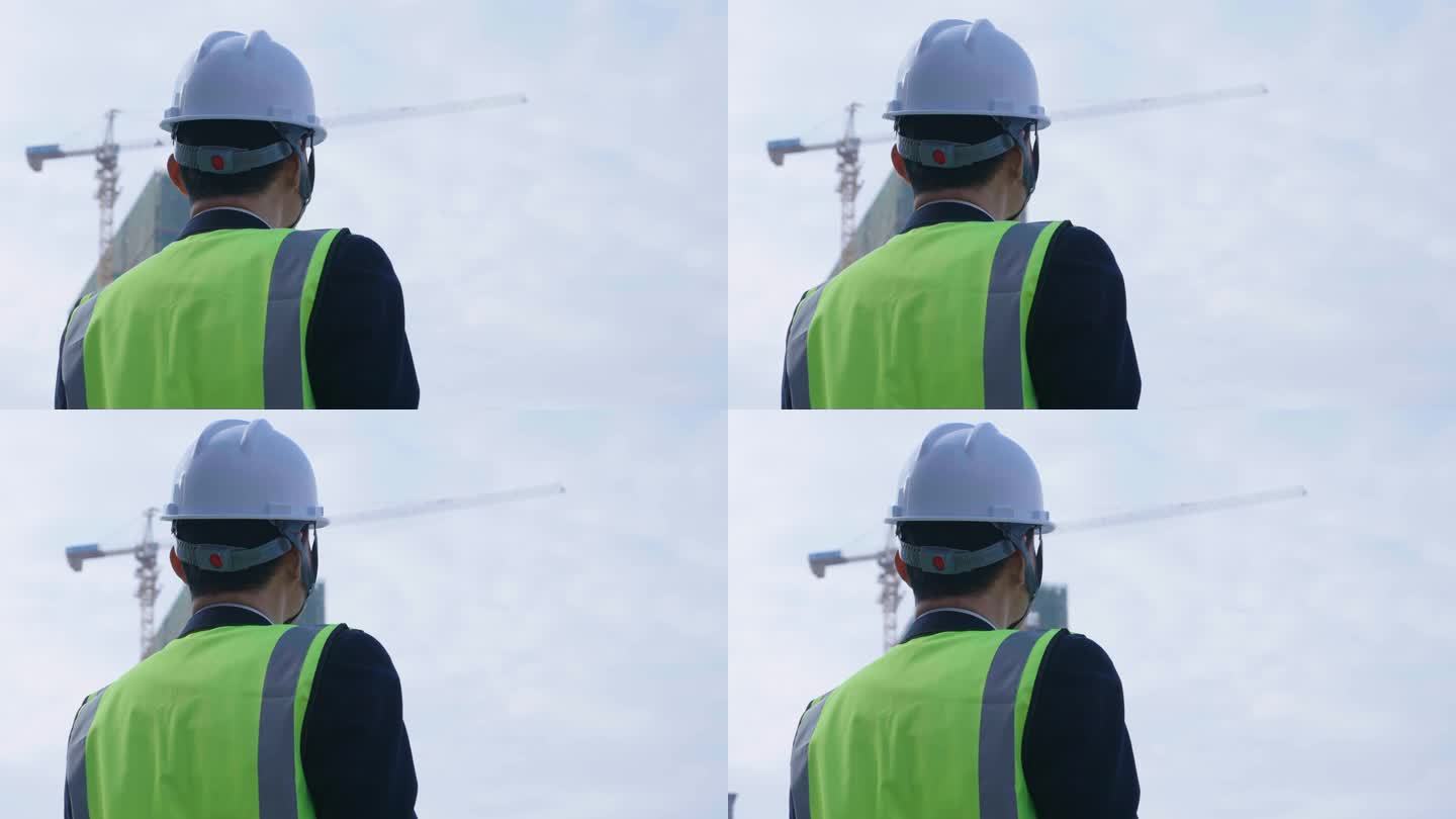 男人戴安全帽勘察建筑工地背影
