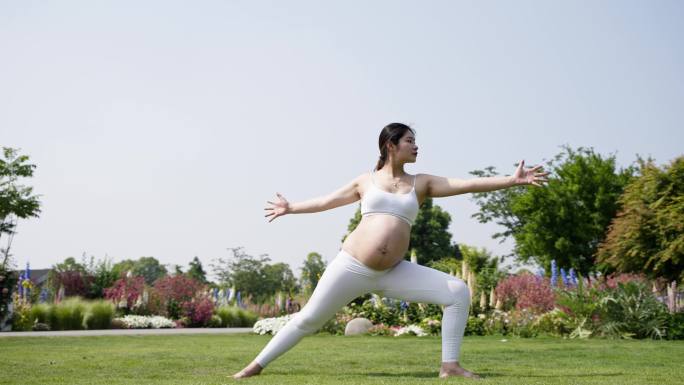 怀孕的女人孕妇在草地上锻炼身体做瑜伽