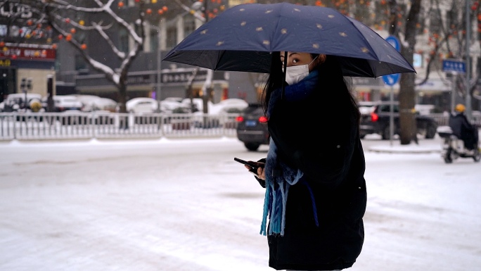 下雪天路人出行 行人背影