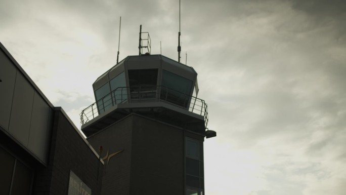 低角度看机场塔台对天空中的云。空中交通管制，现代建筑的剪影。机场及航空概念