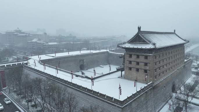 航拍陕西省西安市大雪中的西安安远门古城墙