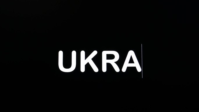 键入乌克兰的字母大写和黑体字显示在电脑屏幕的黑色背景。
