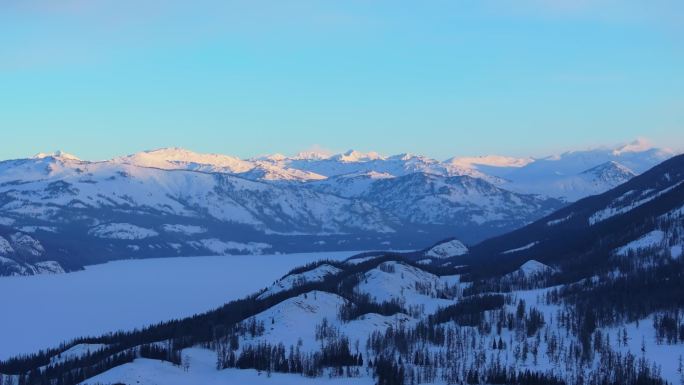 新疆阿勒泰冬季喀纳斯湖雪山水墨画雪景日出