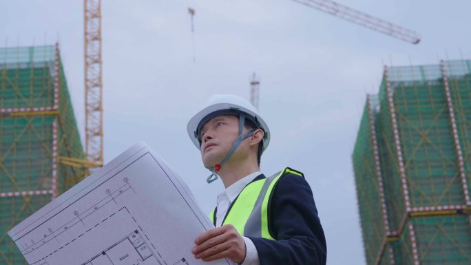 男人手拿建筑设计图纸建筑工地