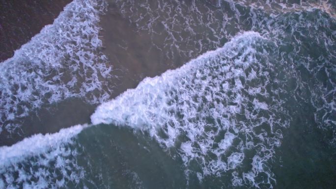 鸟瞰海浪沿着海岸拍成泡沫