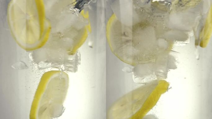 柠檬和冰块在水里旋转高清