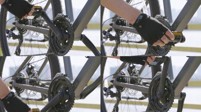 手握自行车踏板齿轮链条特写