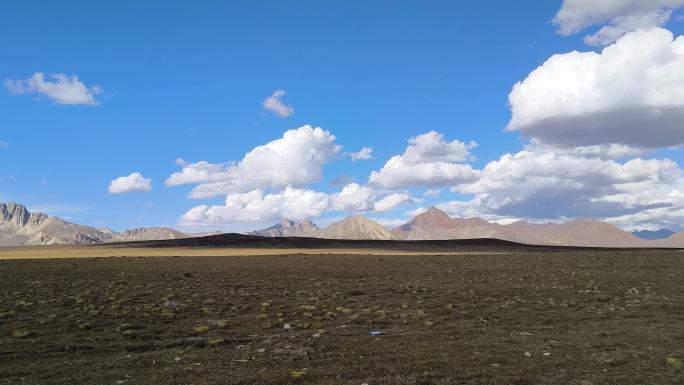 西藏巴塘远观措普沟景区的雪山天空云彩环抱