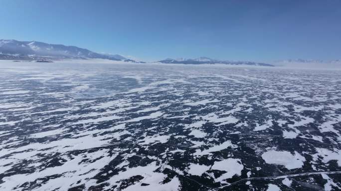 航拍新疆冬季赛里木湖冰封湖面雪山冰湖雪景