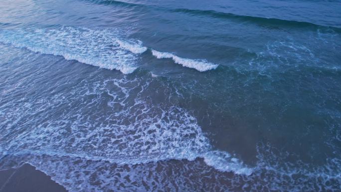 鸟瞰海浪沿着海岸拍成泡沫
