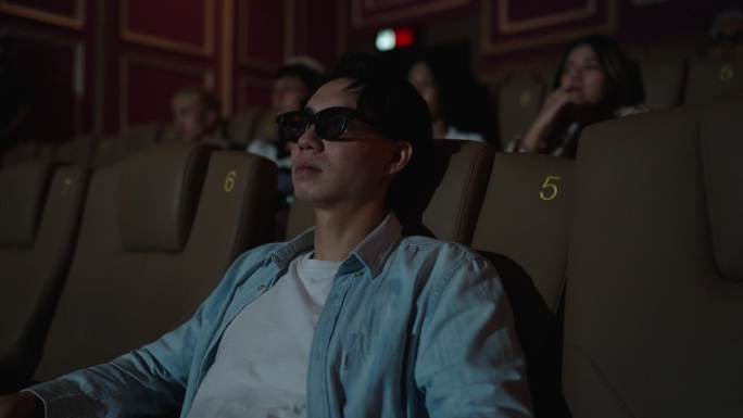 一名男子在电影院沉浸在恐怖的电影体验中。