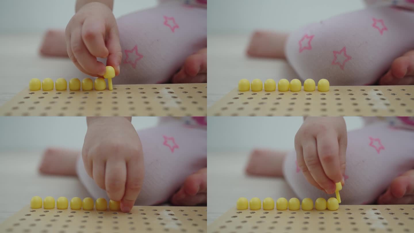 一个2.5岁的小孩在玩彩色马赛克，把它铺在衬底上。