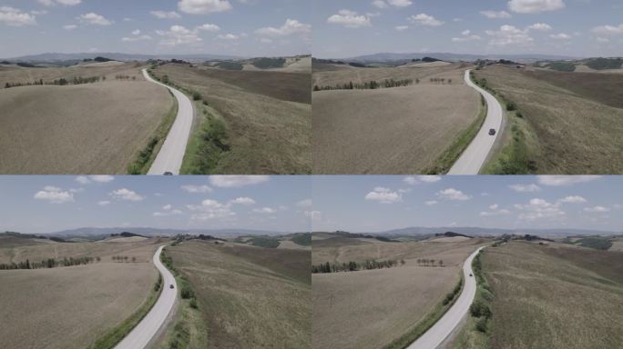 无人机拍摄的蜿蜒的道路和金色的农场在意大利托斯卡纳风景晴朗的一天，蓝天和云在地平线上LOG