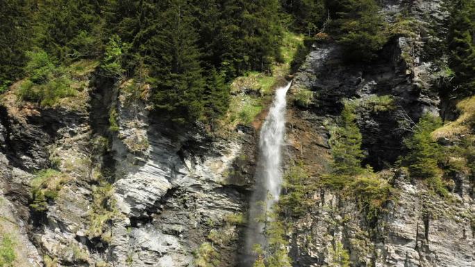 在欧洲，法国，在阿尔卑斯山的博福特，在夏天，在一个阳光明媚的日子里，一个绿色和岩石悬崖中间的瀑布。