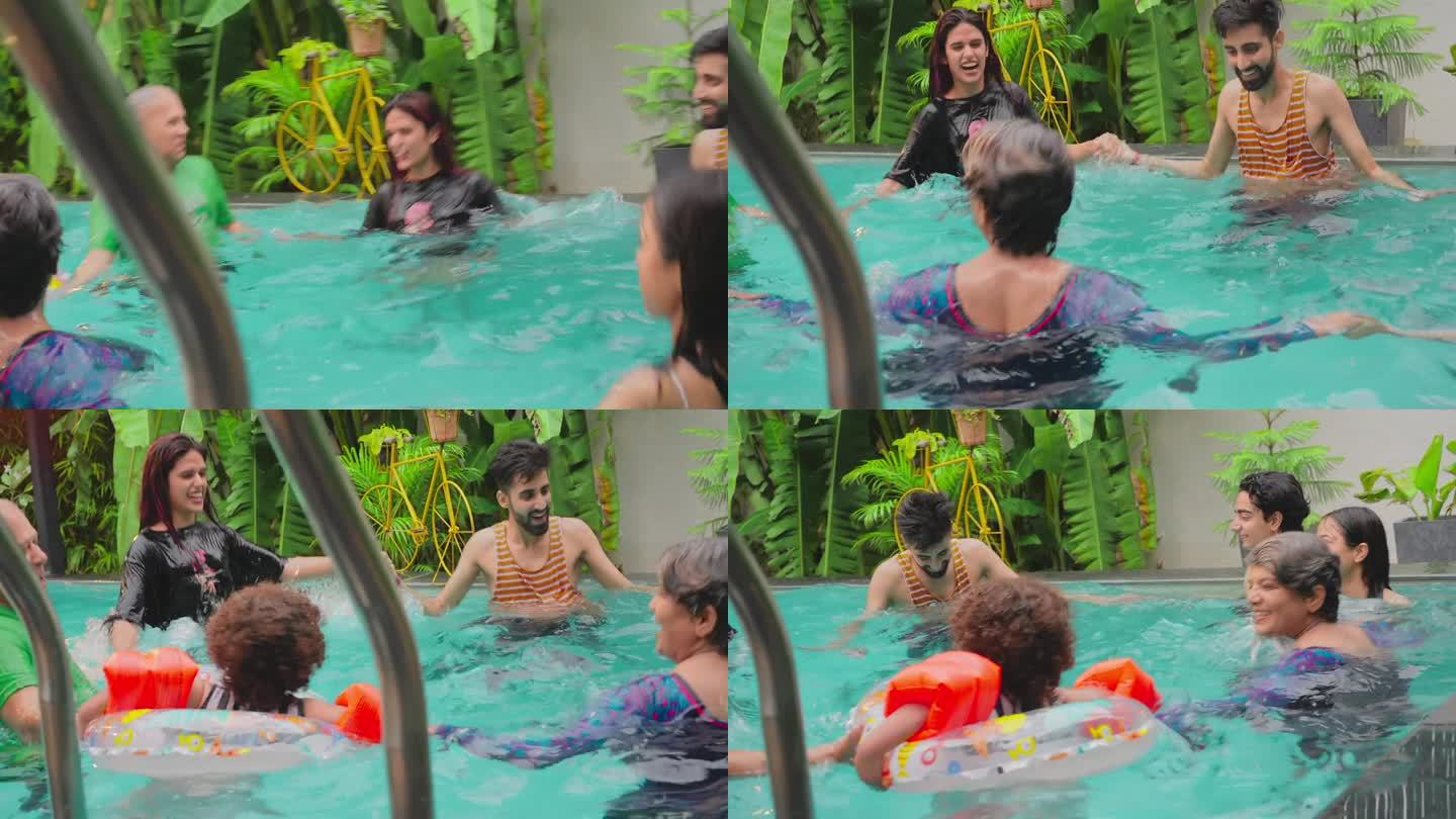 快乐的印度朋友在游泳池里手拉手围成圈，一起在户外水上乐园度假。微笑的大龄中年祖父母兄弟姐妹度假屋酒店