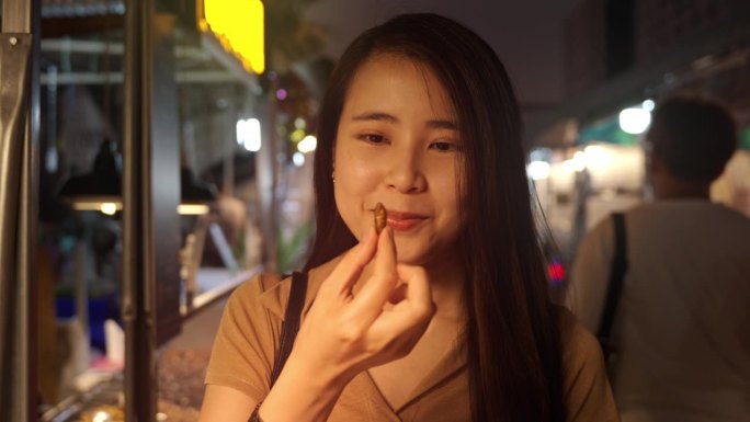 亚洲妇女吃炸蚕蛹