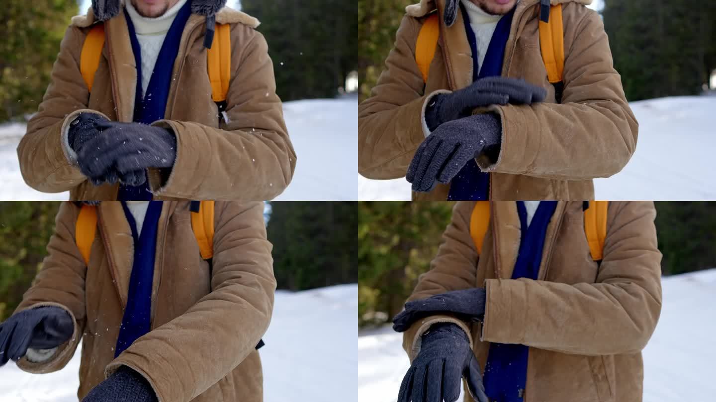 男人抖掉手套和夹克上的雪花