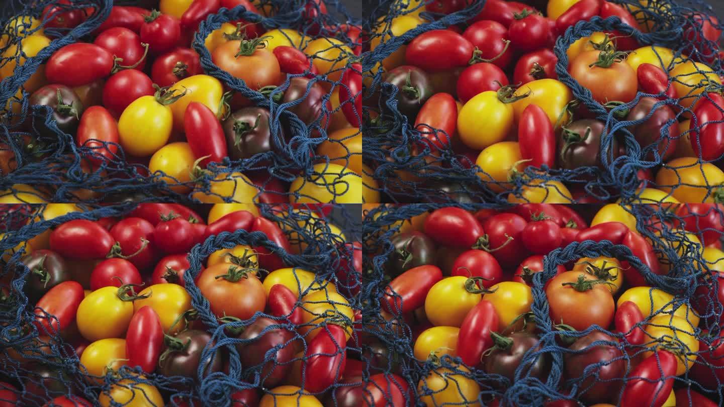 网袋里有黄色的红番茄旋转。新鲜番茄背景