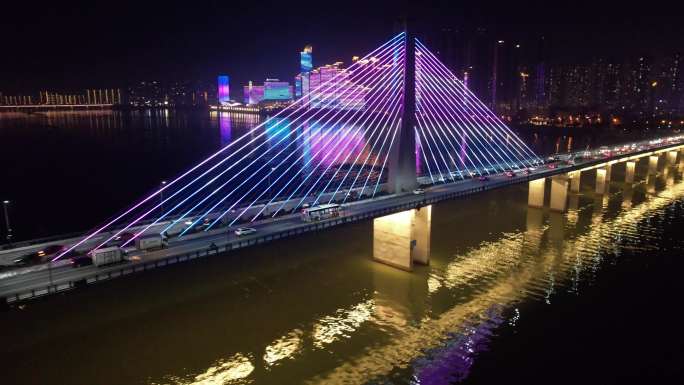 航拍夜晚行驶在跨江大桥上的公交车