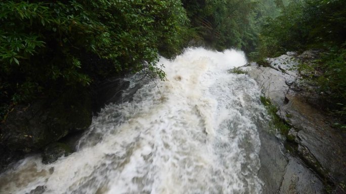 雨季的瀑布。峡谷之间湍急的瀑布河。大雨过后，泥土正在往下移。巨大翻滚的棕色浑水。4k慢动作镜头b滚拍