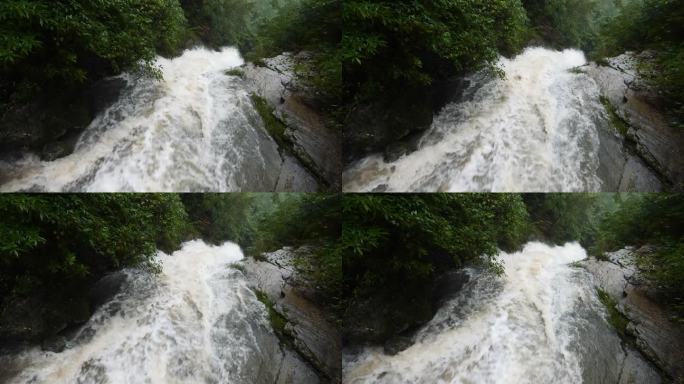 雨季的瀑布。峡谷之间湍急的瀑布河。大雨过后，泥土正在往下移。巨大翻滚的棕色浑水。4k慢动作镜头b滚拍