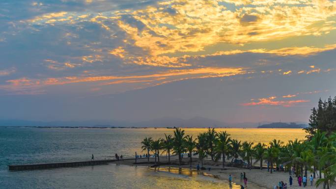 海南海边沙滩码头椰树度假游人夕阳日落延时