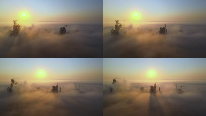 雾蒙蒙的早晨，工业生产现场高耸混凝土厂房结构和塔吊的水泥厂鸟瞰图。制造和全球产业理念