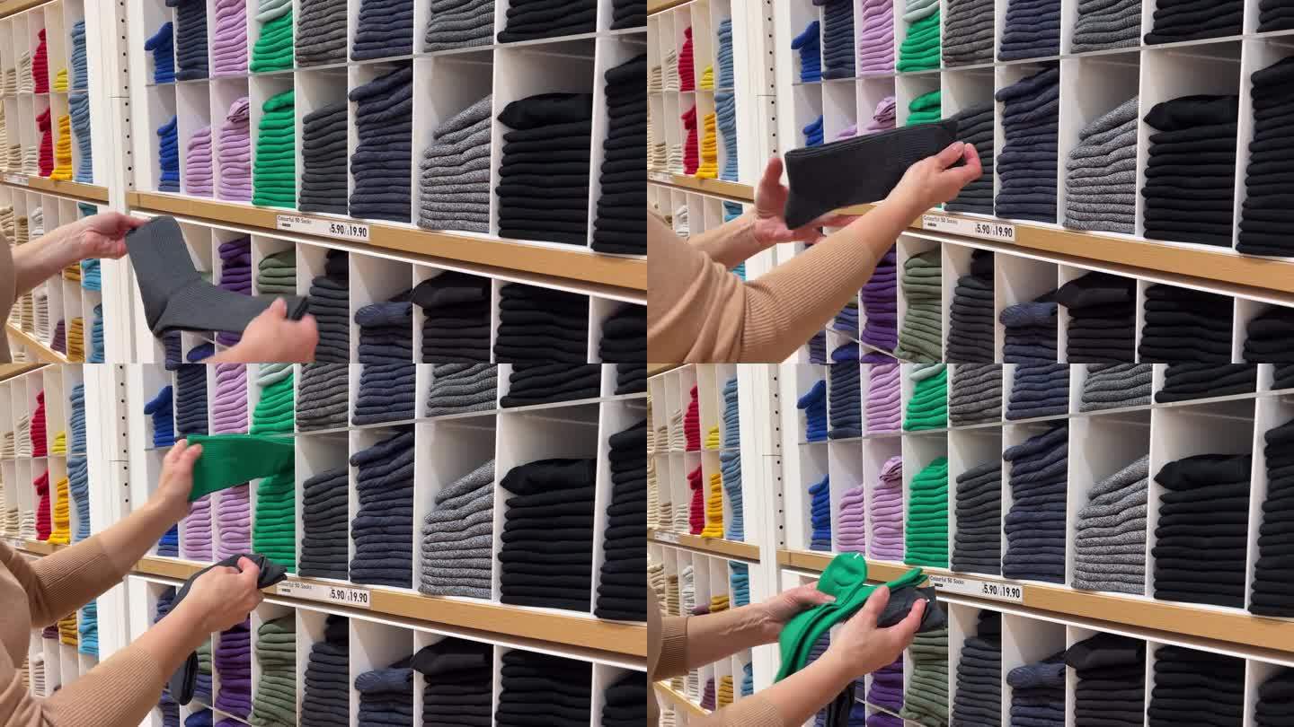 买袜子。一位女士在百货公司挑选打折的袜子。服装店的货架上摆放着不同颜色的袜子。