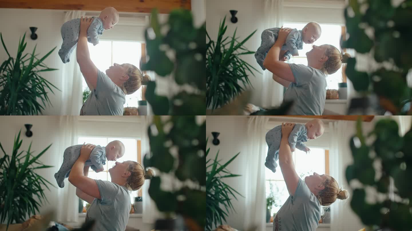 SLO - MO侧视图手持拍摄欢快的母亲在光明之家抱起男婴
