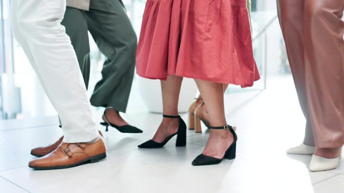 商务人士穿着鞋子和高跟鞋在办公室地板上跳舞庆祝。兴奋的员工在工作场所欣赏音乐、团队建设或共同赢得时尚