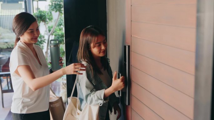 两个女人用生物指纹扫描仪打开家门——安全便捷的城市生活