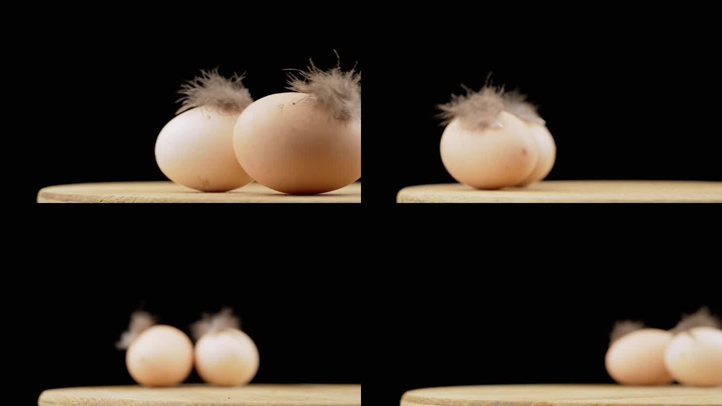 两个带羽毛的棕色鸡蛋放在旋转木桌上，黑色背景