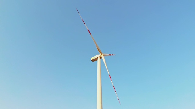 空中风力发电宁静:单个涡轮机旋转在晴朗的蓝天
