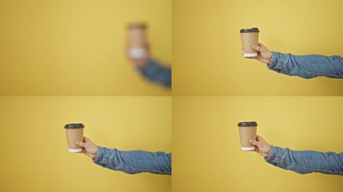 一个人伸出手臂，在纯黄色的背景下，拿着一个一次性咖啡杯，重点是休闲的生活方式。