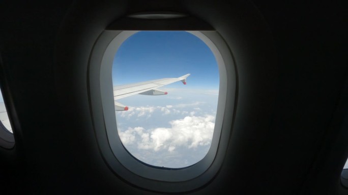 镜头:飞机乘客在飞行过程中掀起了飞机窗户的百叶窗