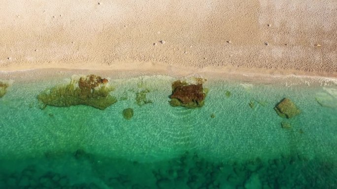 航拍无人机俯瞰海浪拍打沙滩。美丽的海水涌向海滩。梦想的绿岛之旅。户外探险旅行到美丽的海滩。