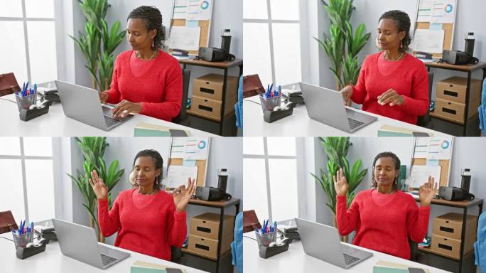 穿着红色毛衣的成熟非洲妇女坐在办公桌前沉思，办公桌上有一台笔记本电脑和文具。