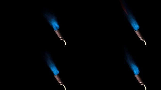 燃气燃烧器火焰。黑色背景上孤立的蓝色火焰，特写。蓝色火焰从燃气火炬的喷嘴打开。手动丁烷燃烧器火焰。视