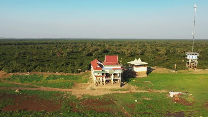 在一个阳光明媚的夏天，位于洞里萨湖岸边的一所房子，正对着亚洲柬埔寨暹粒的绿色乡村。