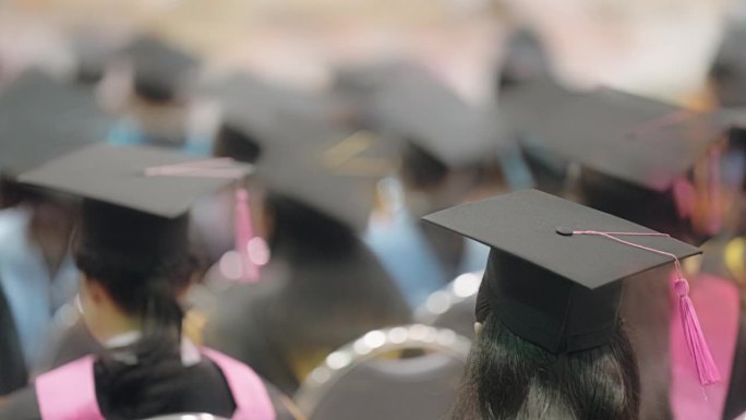 鸟瞰图戴着毕业帽和毕业服的毕业生在大学祝贺毕业生