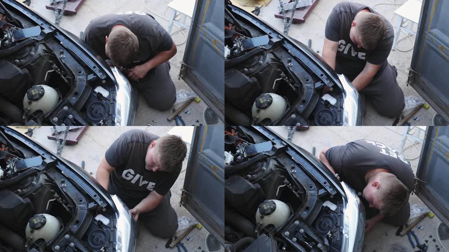 年轻的汽车修理工正在修理汽车前灯。