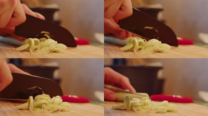 一个拿着刀的男人正在准备晚餐。韭菜切块待炒。把韭菜放在砧板上。洋葱。常见onionis