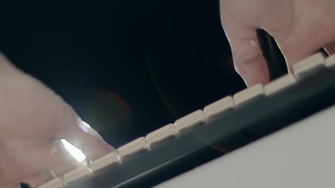 一名男子在合成器键盘上演奏(钢琴)