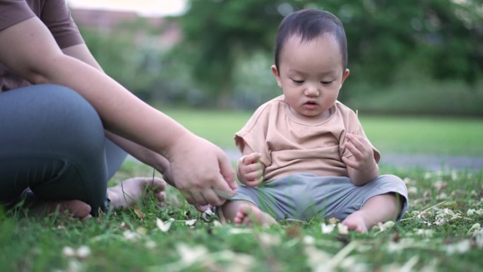 母亲带着男婴在公园户外玩耍