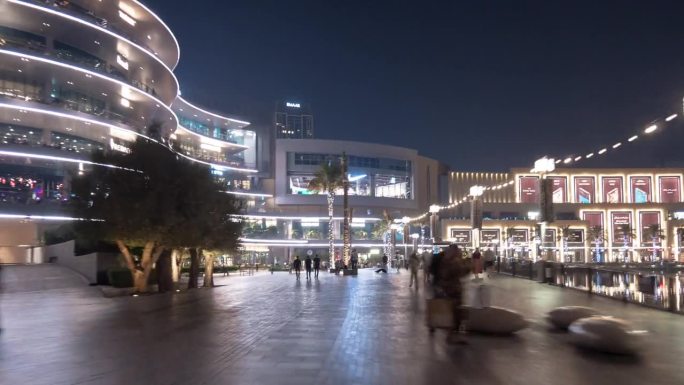 夜间照明迪拜市著名的市中心购物中心喷泉拥挤的广场步行全景4k延时阿联酋