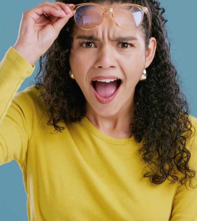 惊喜，哇和妇女的脸在蓝色背景的折扣新闻，交易信息和八卦。天哪，眼镜和人的肖像，震惊的反应，宣布和出售