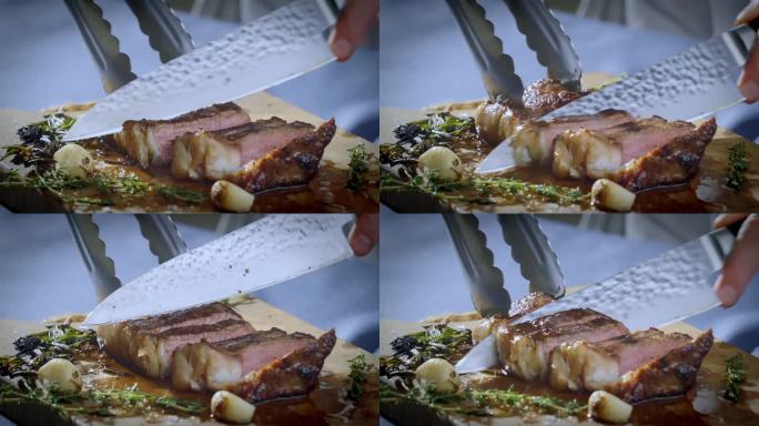 厨师在菜板上用一把大菜刀切牛排。多汁的牛排被切成块。慢动作视频。